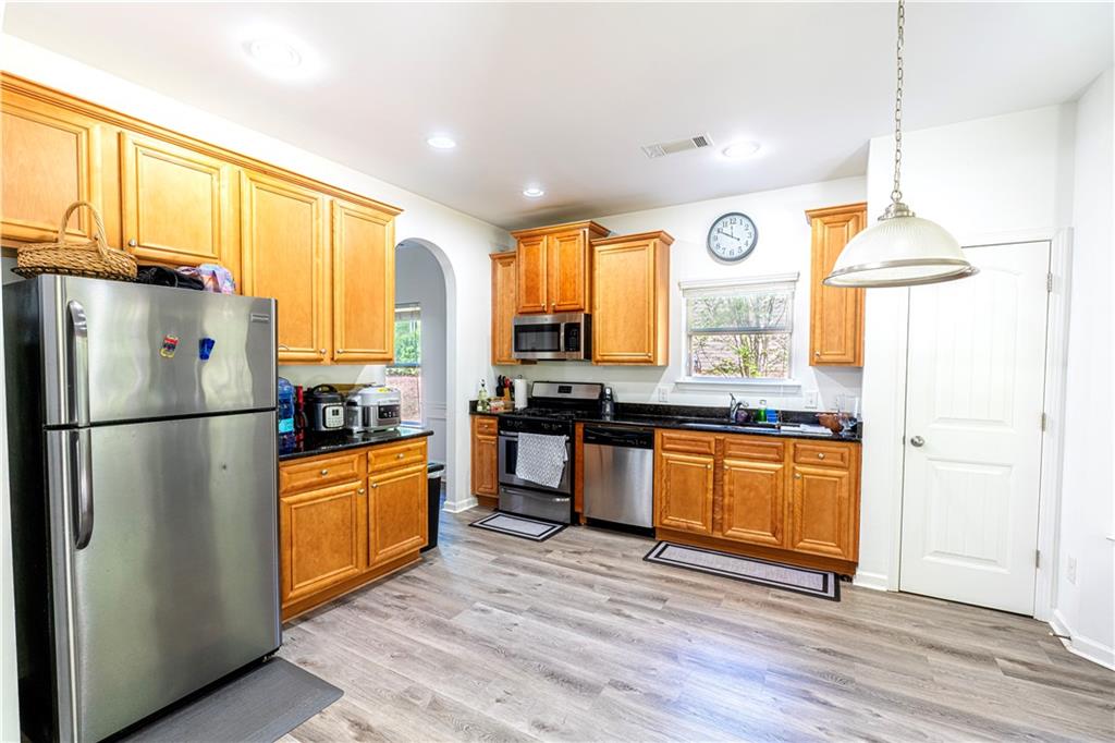 5555 Hedge Brook Drive Cumming, GA 30028 - Photo 7 of 15 a kitchen with stainless steel appliances granite countertop a refrigerator a stove a sink and a wooden floors