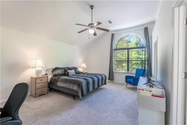a bedroom with bed and a large window