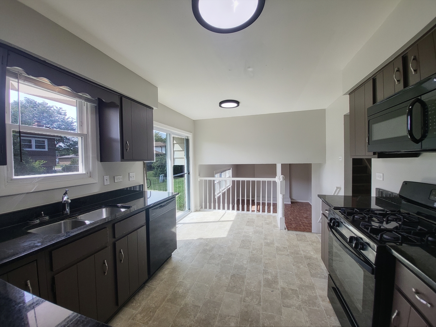 6037 Spring Lane Matteson, IL 60443 - Photo 16 of 29 a kitchen with stainless steel appliances granite countertop a stove a sink and a microwave