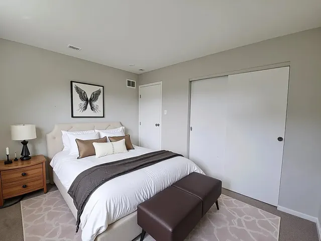 a bedroom with a bed and a painting on the wall