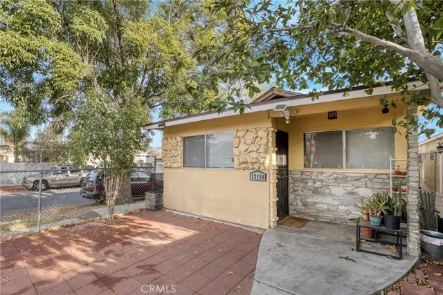 a view of a white house with a large tree