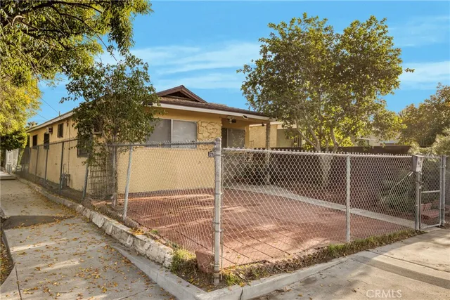 a view of a house with a small yard and wooden fence