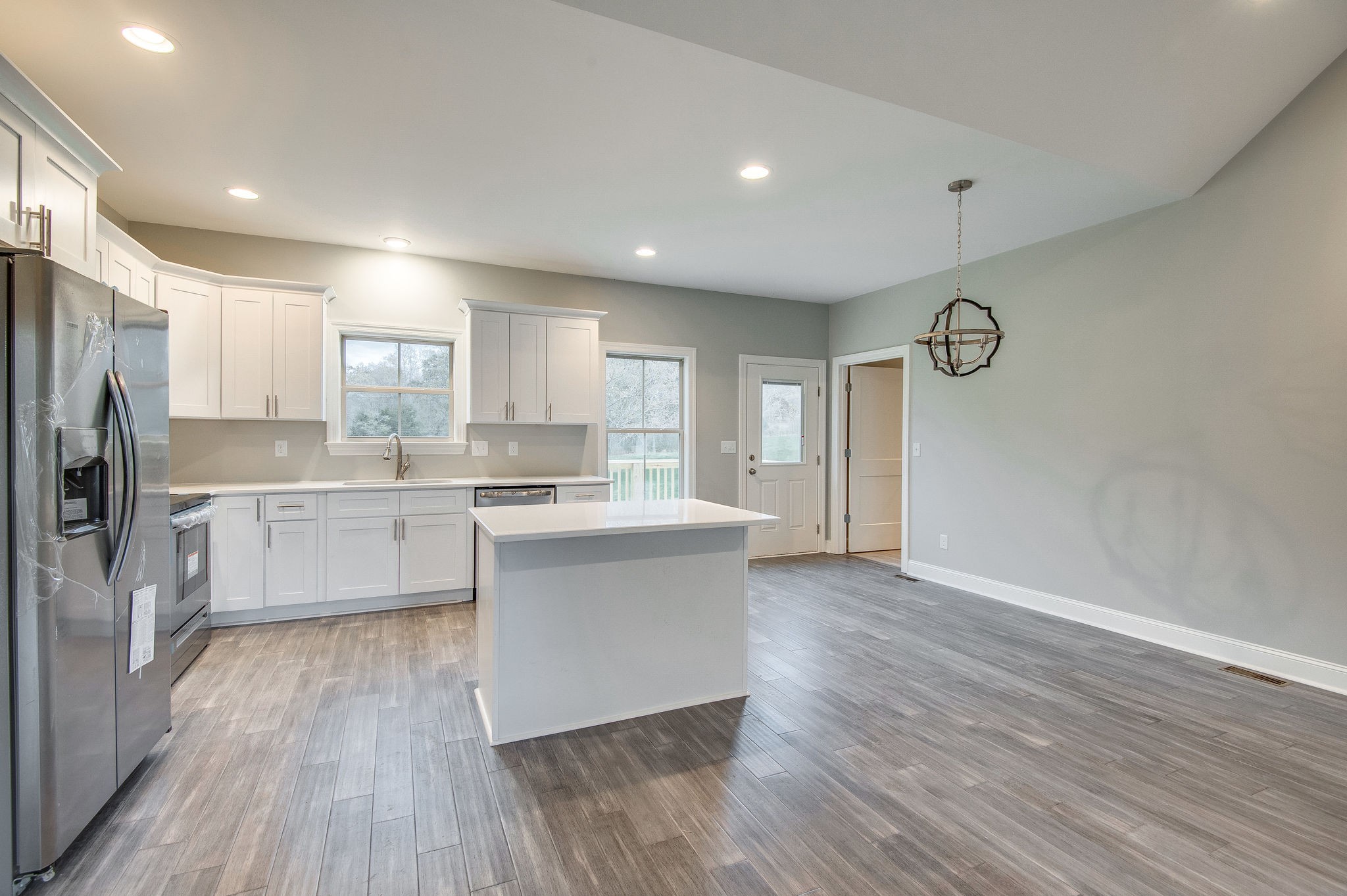 895 Goslin Branch Road Burns, TN 37029 - Photo 12 of 30 a large kitchen with a center island wooden floor stainless steel appliances and cabinets