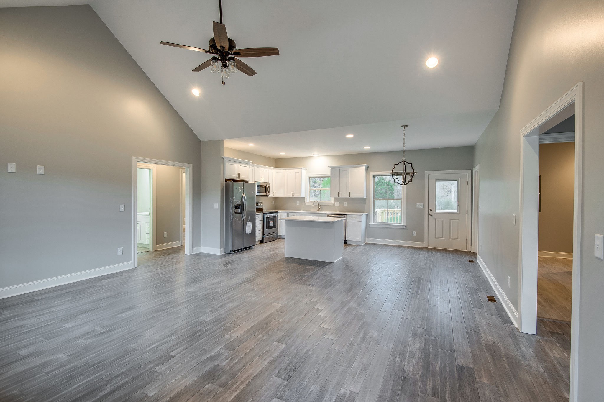 895 Goslin Branch Road Burns, TN 37029 - Photo 2 of 30 a view of a big room with wooden floor a ceiling fan and windows