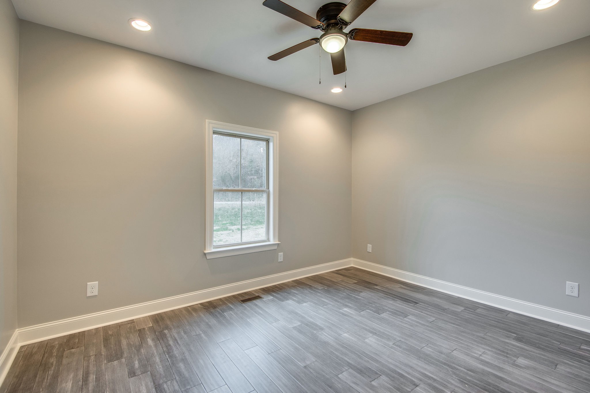 895 Goslin Branch Road Burns, TN 37029 - Photo 21 of 30 an empty room with wooden floor fan and windows