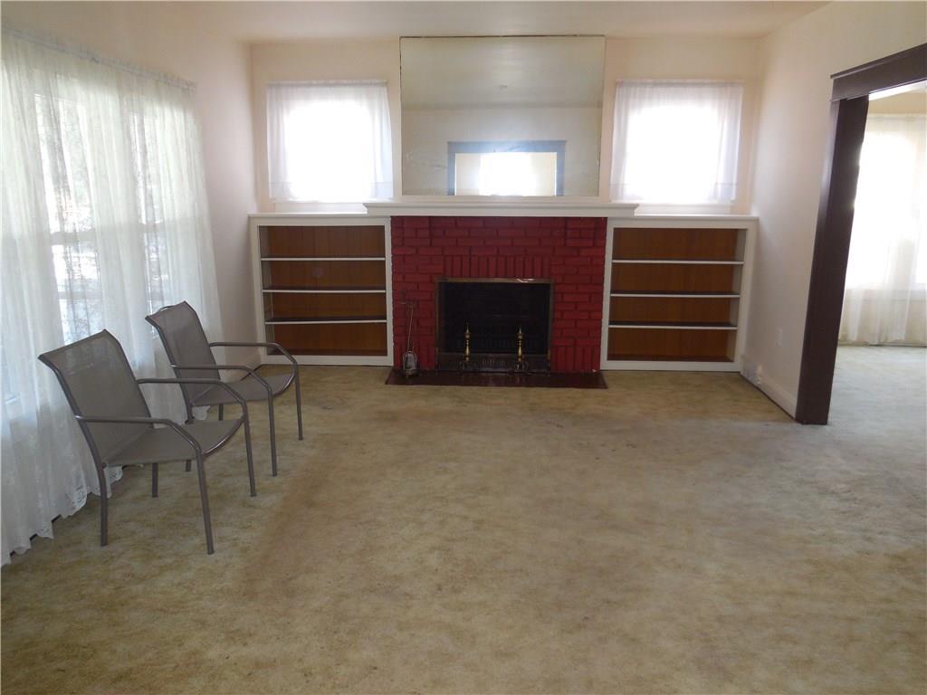 933 Indiana Avenue Monaca, PA 15061 - Photo 5 of 19 Living room has lots of natural light, built in book shelves and wood fireplace. Could be converted to gas. (Has not been used in years.)