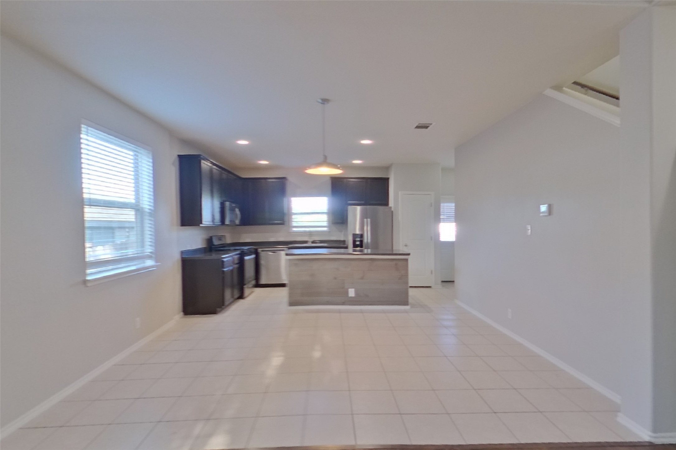 240 Dragon Ridge Road Buda, TX 78610 - Photo 3 of 20 Tiled flooring flows through this open layout toward a functional kitchen with an island.