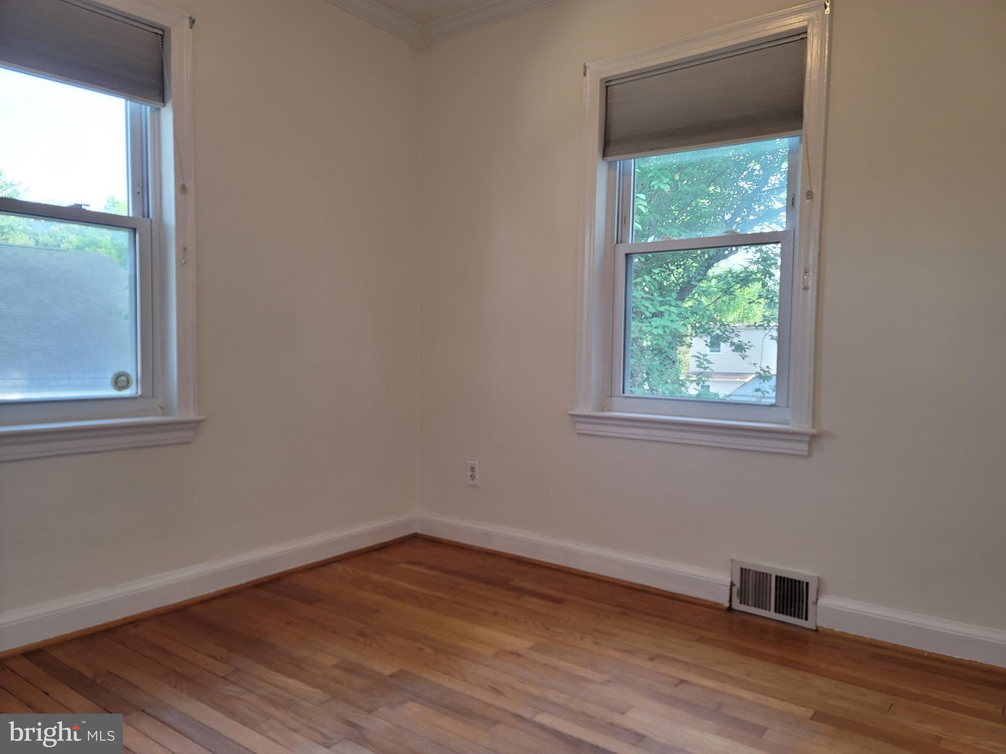 1015 Veirs Mill Road Rockville, MD 20851 - Photo 16 of 57 a view of an empty room with wooden floor and a window