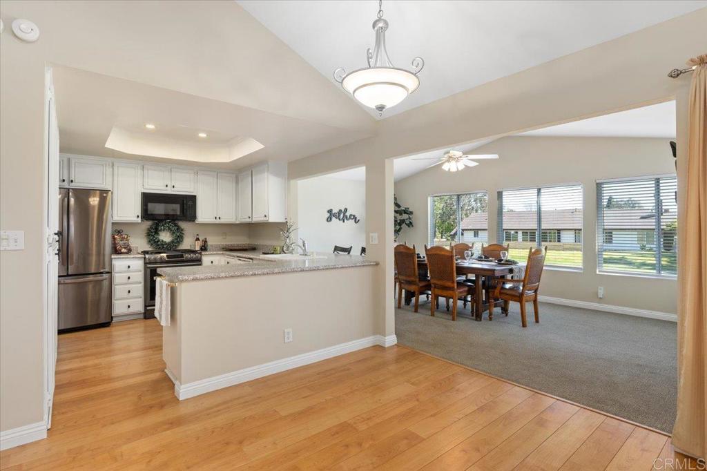 1277 La Casa Drive San Marcos, CA 92078 - Photo 11 of 29 a kitchen with a refrigerator a microwave oven dining table and chairs