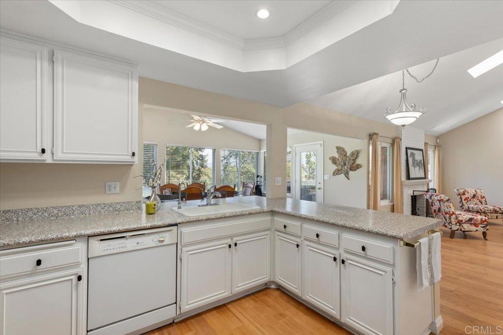 1277 La Casa Drive San Marcos, CA 92078 - Photo 15 of 29 a kitchen with granite countertop white cabinets white appliances with a sink and dishwasher with wooden floor