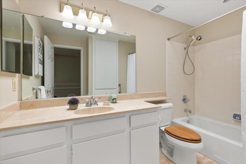 1277 La Casa Drive San Marcos, CA 92078 - Photo 23 of 29 a bathroom with a granite countertop sink a toilet and a mirror