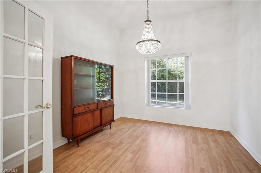 5348 Cypress Lane Naples, FL 34113 - Photo 20 of 28 a view of an empty room with wooden floor and a window