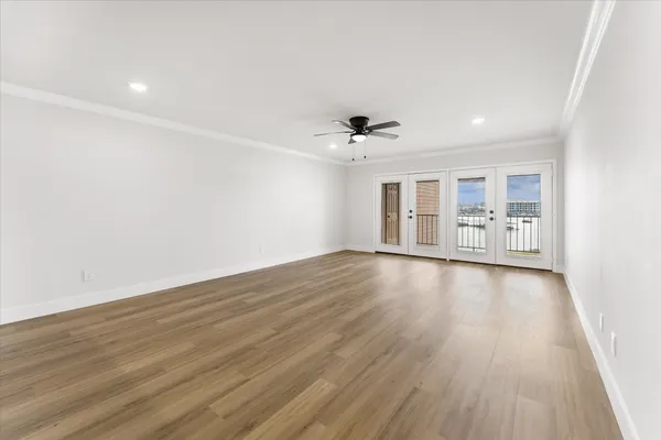 a view of a room with wooden floor and ceiling fan