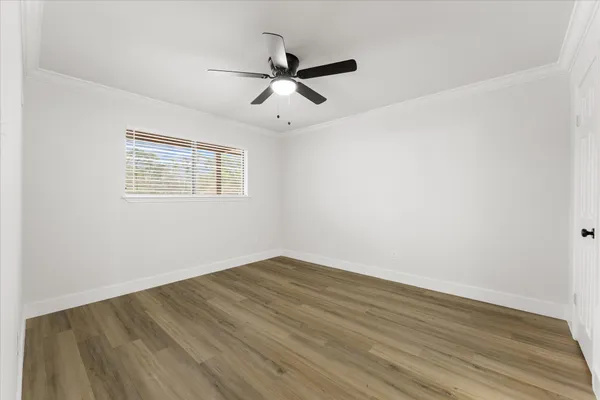 a view of an empty room with wooden floor