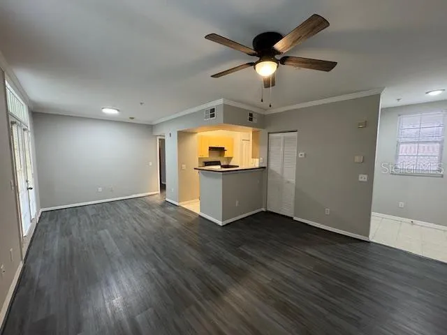 a view of a livingroom with a ceiling fan hardwood floor and a ceiling fan