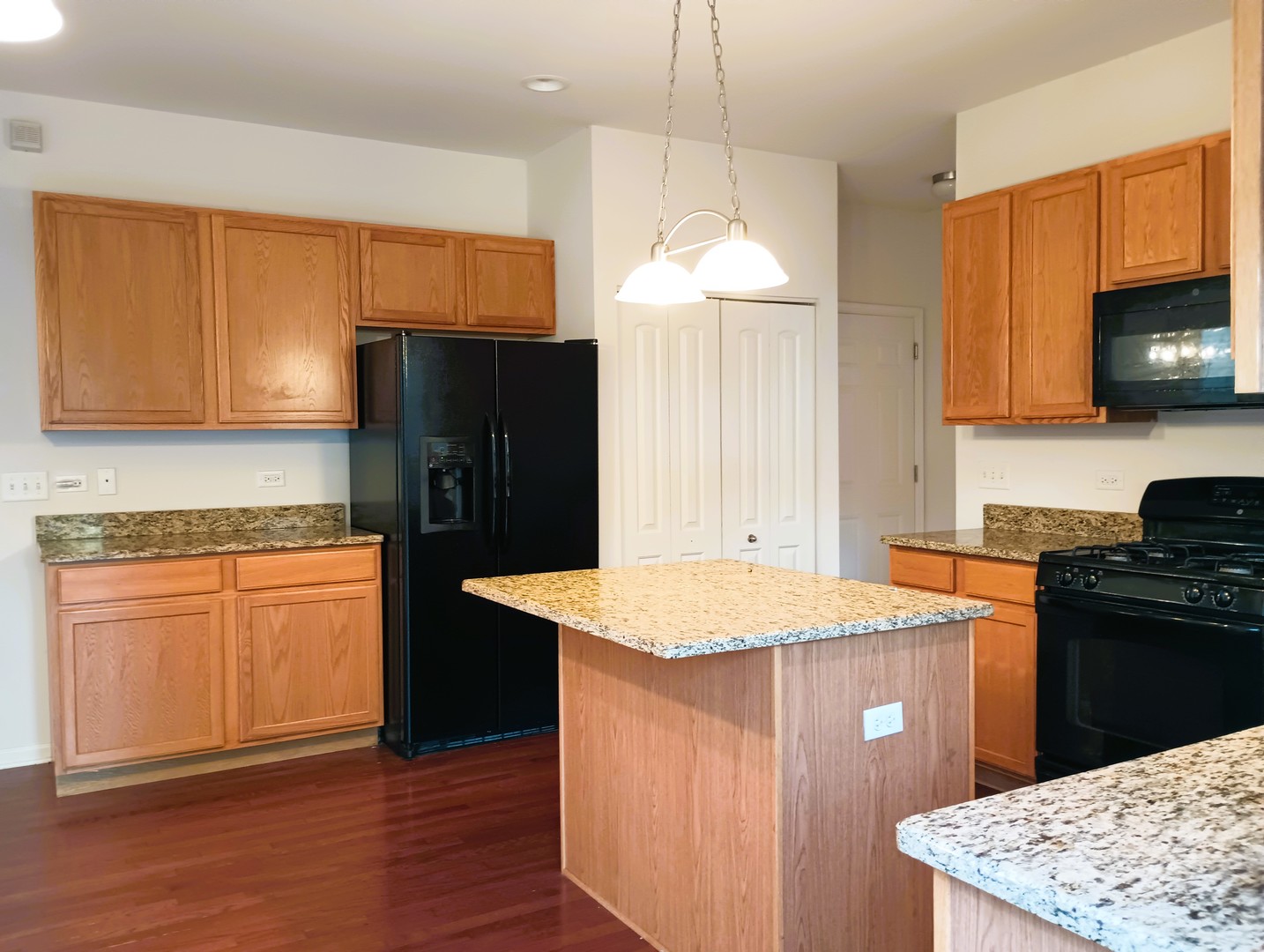 777 West Mystic Lane Romeoville, IL 60446 - Photo 9 of 35 a kitchen with stainless steel appliances granite countertop a refrigerator a sink dishwasher a stove and white countertops with wooden floor