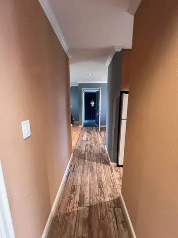 a view of a hallway with wooden floor