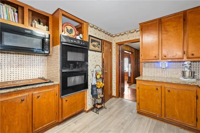 a view of a kitchen with wooden floor and cabinets