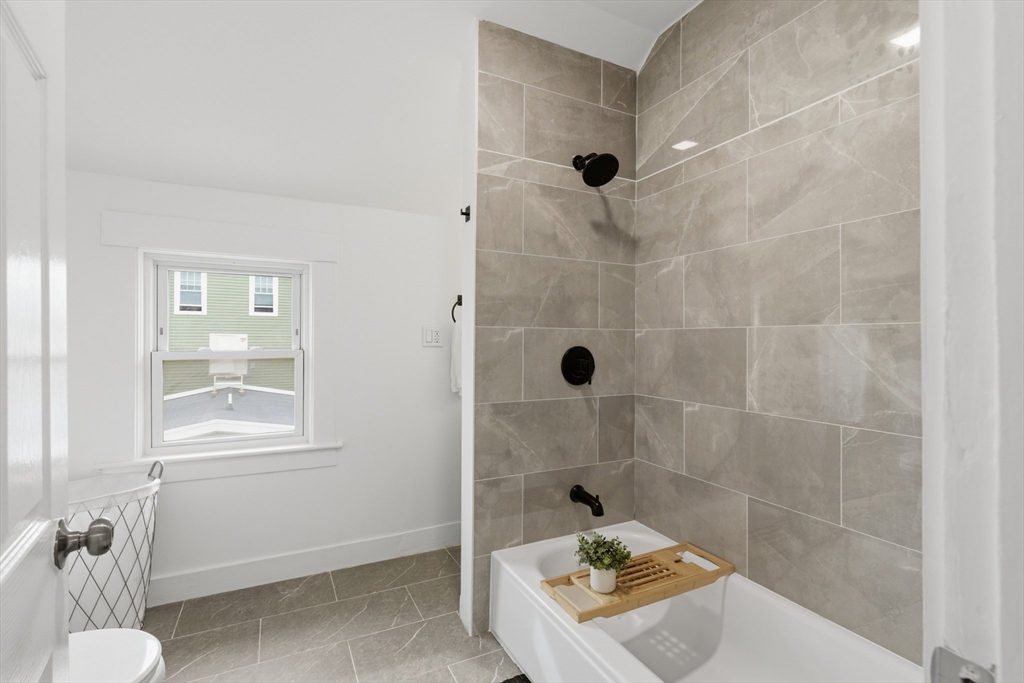9 Robbins Street Waltham, MA 02453 - Photo 26 of 42 a bathroom with a bathtub and shower