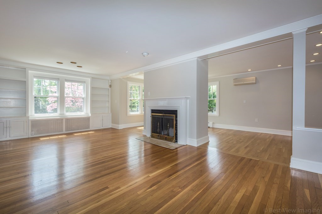 10 Chapin Road Newton, MA 02459 - Photo 6 of 35 an empty room with wooden floor a fireplace and windows