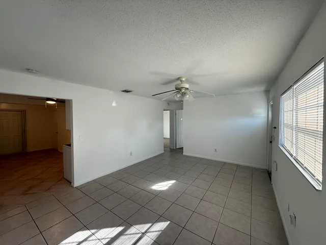 an empty room with windows and fan