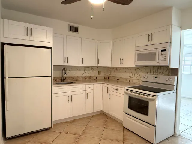 a kitchen with cabinets stainless steel appliances and a counter space