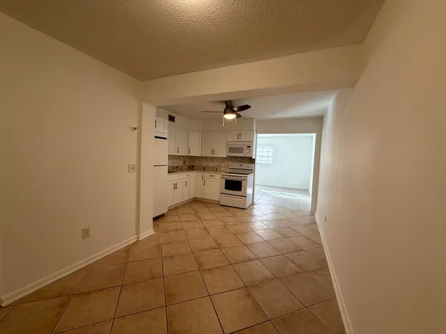 a kitchen with a stove a refrigerator and cabinets