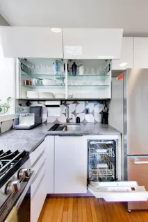 a kitchen with kitchen island granite countertop a sink a stove and a wooden floors