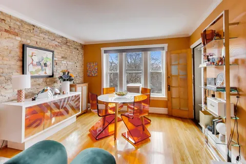 a living room with furniture a large window and stainless steel appliances