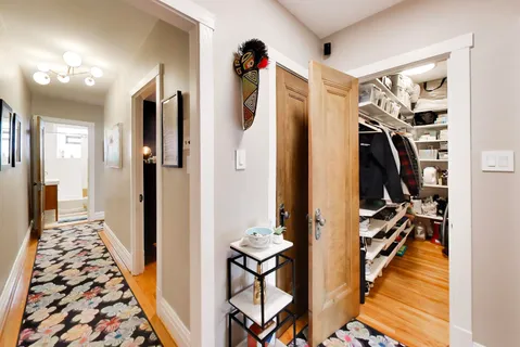 a view of a hallway with wooden floor and windows