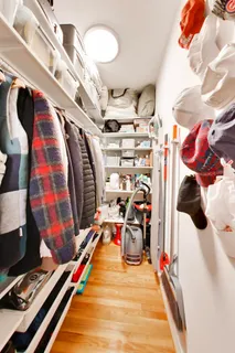a view of walk in closet with clothes and shoes