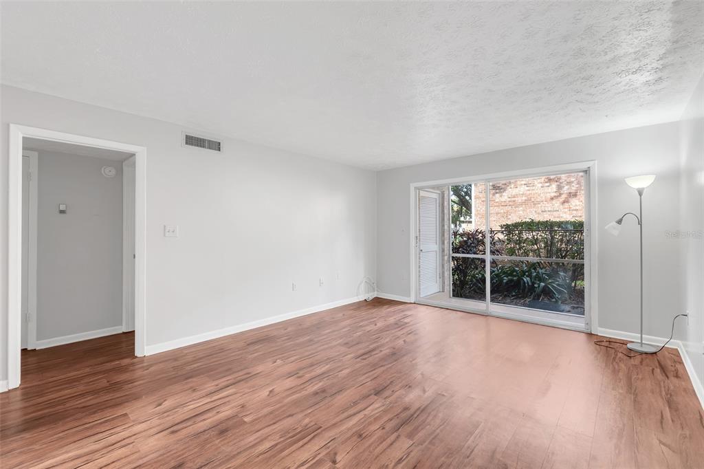 4212 Lake Underhill Road, Unit A Orlando, FL 32803 - Photo 7 of 35 an empty room with wooden floor and windows