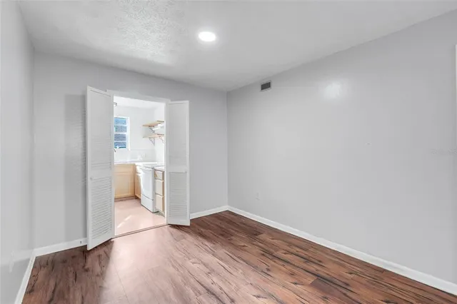 a view of a room with wooden floor and white walls