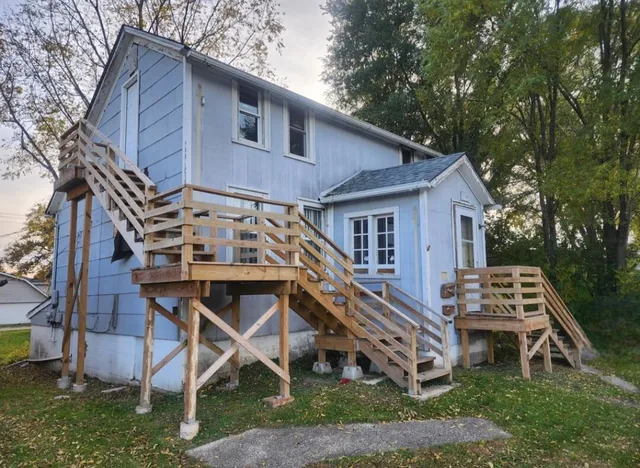 a view of a house with backyard and trees