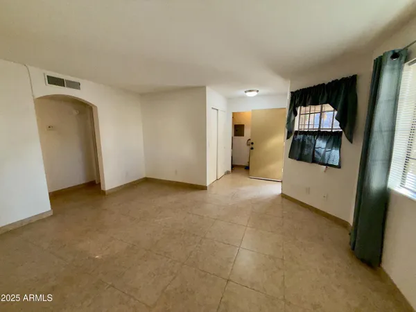 an empty room with windows and fan