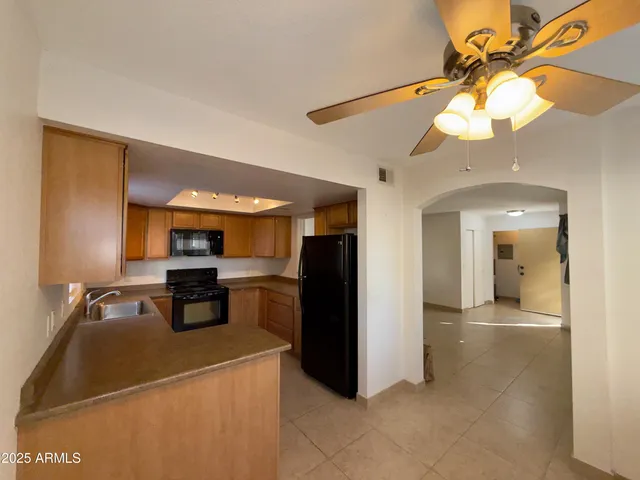 a kitchen with stainless steel appliances granite countertop a refrigerator a stove and a sink