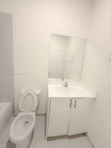 a bathroom with a toilet a sink and mirror