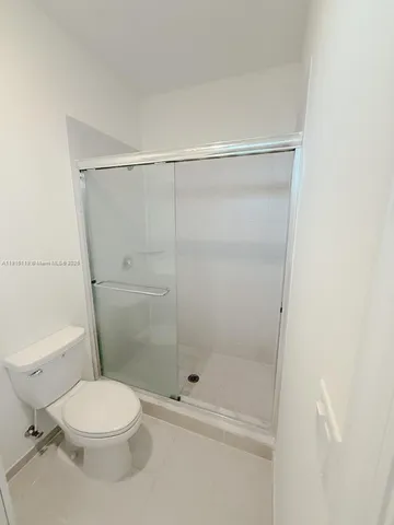 a white toilet next to a bathroom
