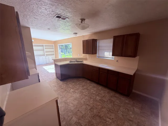 a kitchen with stainless steel appliances a sink a microwave a refrigerator and cabinets