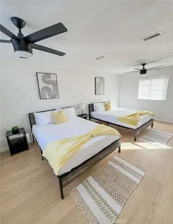 a bedroom with two beds and a desk