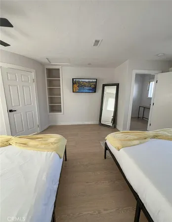 a spacious bedroom with a bed and a dresser