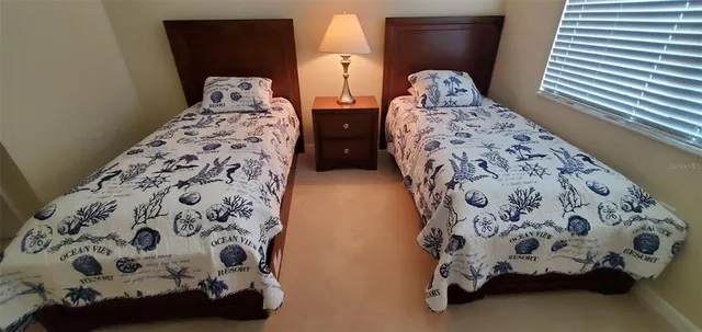 a bedroom with two bed and a window