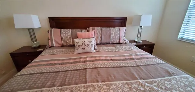 a bed sitting in a bedroom next to a window with lamp