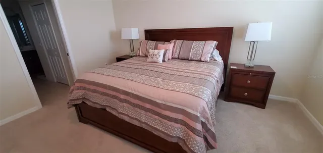 a bedroom with a bed and a lamp on dresser