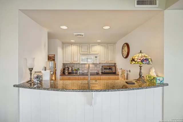 a view of a kitchen with kitchen island and stainless steel appliances
