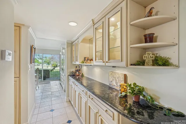 a large white kitchen with a large window and a potted plant