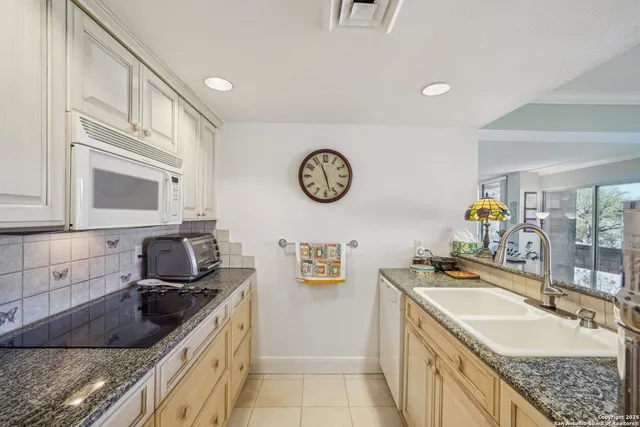 a kitchen with stainless steel appliances granite countertop a sink stove and cabinets