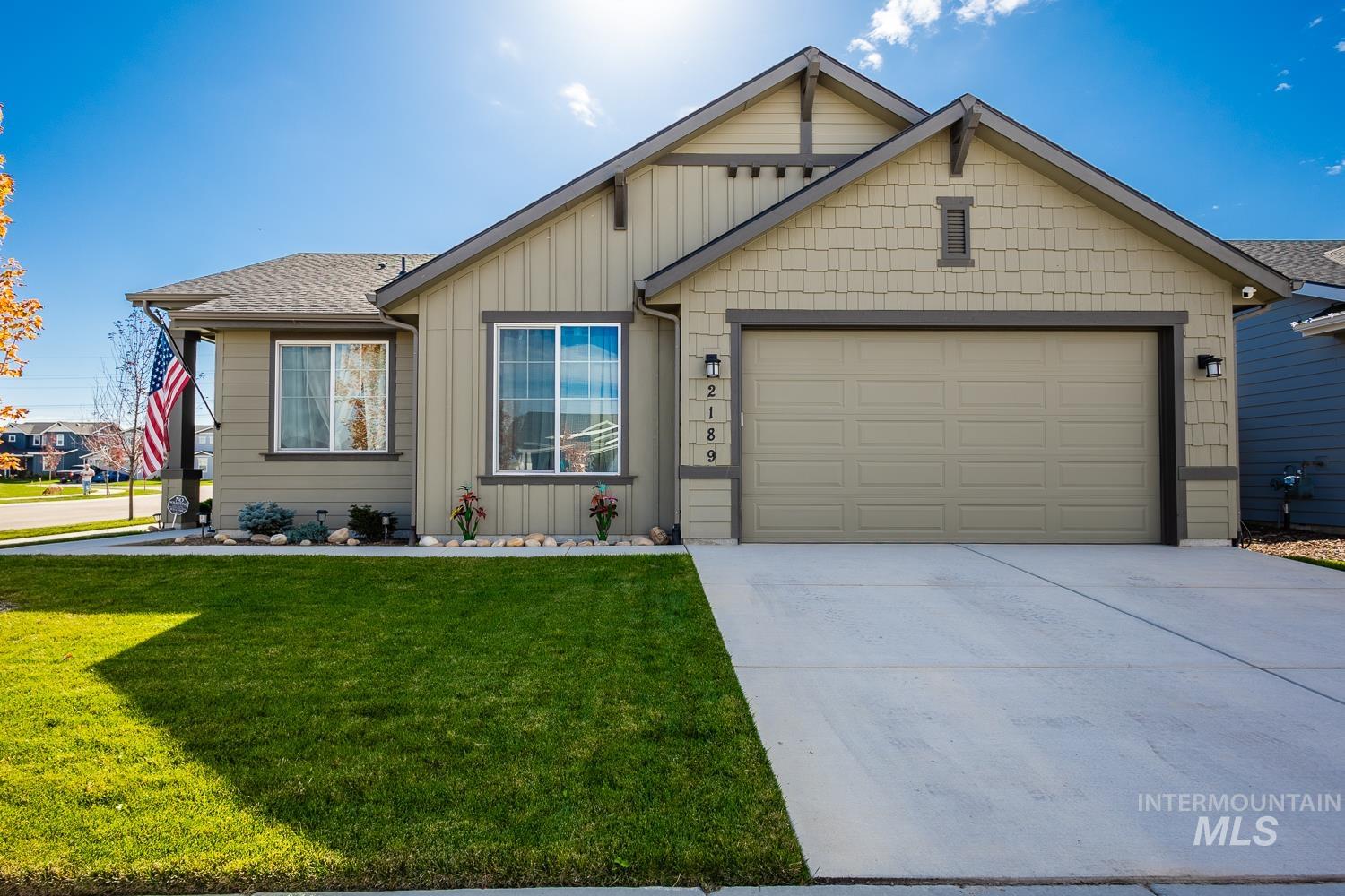 Ranch-style house featuring concrete driveway, a front lawn, board and batten siding, and a garage
