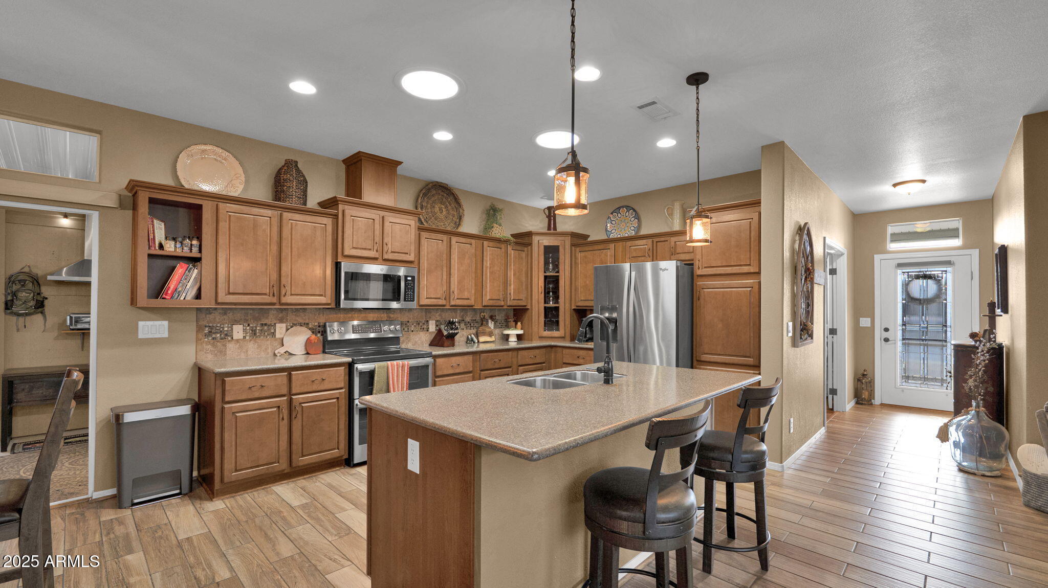 3301 South Goldfield Road, Unit 6014 Apache Junction, AZ 85119 - Photo 4 of 57 a kitchen with stainless steel appliances kitchen island granite countertop a refrigerator a stove a sink a dining table and chairs with wooden floor