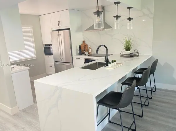 a kitchen with stainless steel appliances a table and chairs